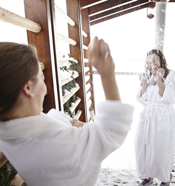 Zwei Freundinnen machen eine Wasserschlacht im Wellnessbereich des Haubers Naturresorts in Oberstaufen.