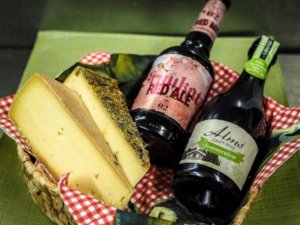 Zwei Flaschen Wein und Käse in einem Korb im Allgäuhotel Tanneck in Fischen