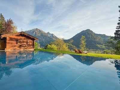 Außenpool des Hotel Prinz-Luitpold-Bads in Bad Hindelang an einem sonnigen Sommertag mit Blick auf das Bergpanorama