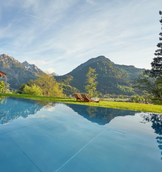 Außenpool des Hotel Prinz-Luitpold-Bads in Bad Hindelang an einem sonnigen Sommertag mit Blick auf das Bergpanorama