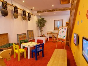 Einblick in das Spielzimmer im Hotel Mühlenhof in Oberstaufen mit Blick auf Sitzgelegenheiten für Kinder und Bildschirme für Kinderspiele