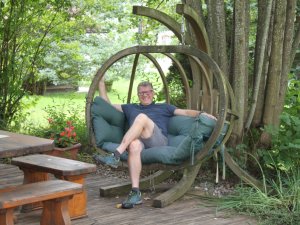 Der Hotelier vom Hotel Mühlenhof in Oberstaufen sitzt im Garten in einem Hängesessel