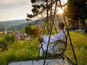 Eine Frau genießt eine Auszeit in der Eisenschaukel im Außenbereich des Hotel Prinz-Luitpold-Bads in Bad Hindelang