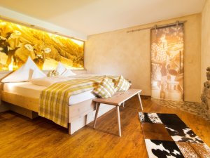 Einblick in eines der hellen und modern eingerichteten Zimmer mit gemütlichem Doppelbett im Allgäuhotel Tanneck in Fischen