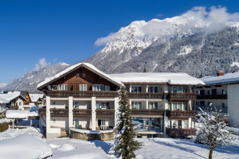 Winterliche Außenansicht des Hotels Garni Schellenberg in Oberstdorf.
