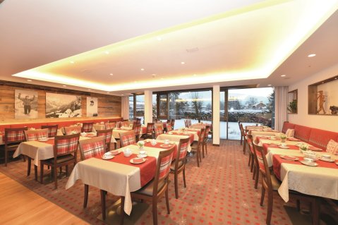 Restaurant eingedeckt zum Frühstücksbuffet im Hotel Schellenberg in Oberstdorf mit Blick in die verschneite Natur.
