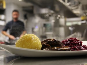 Ein Mitarbeiter der Küche hat eine Speise im Hotel Mohren in Oberstdorf ansprechend angerichtet