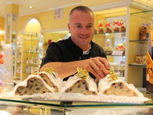 Ein Konditor verziert einen Stollen in der eigenen Konditorei im Hotel Schlosskrone in Füssen
