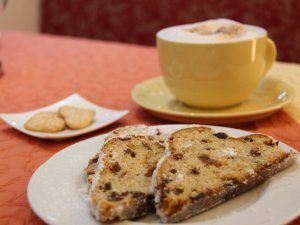 Zwei Stück Stollen und eine Tasse Kaffee auf einem Tisch in der eigenen Konditorei des Hotels Schlosskrone in Füssen