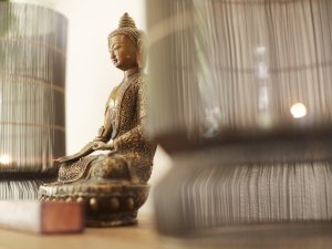 Eine Buddha Figur als Dekoration im Wellnessbereich im HUBERTUS Mountain Refugio Allgäu in Balderschwang.
