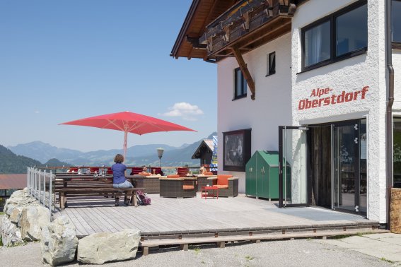 Nehmen Sie Platz und genießen Sie das rundum Panorama auf der Terrasse der Alpe Oberstdorf. Der Blick auf die Berge von Oberstdorf und dem Kleinwalsertal ist einfach nur atemberaubend.