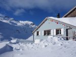 Schnee bedeckte Hütte in den Alpen