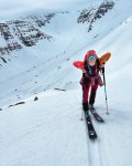 Skifahren in den Bergen bei kaltem Wetter Eine Person fährt Ski in den Bergen. Es gibt viel Schnee und hohe Berge. Der Himmel ist bewölkt.