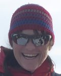 Höhepunkt einer Bergwanderung im Winter Eine Person lächelt in winterlicher Berglandschaft mit Schnee und Sonnenbrille auf. Die Bergwanderung findet statt.