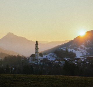 Pfronten bei Sonnuntergang mit Kirchturm