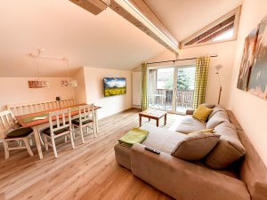 Wohnzimmer mit Essbereich und Balkon Das Bild zeigt ein Wohnzimmer mit einem Essbereich. Der Raum hat große Fenster und einen Balkon.
