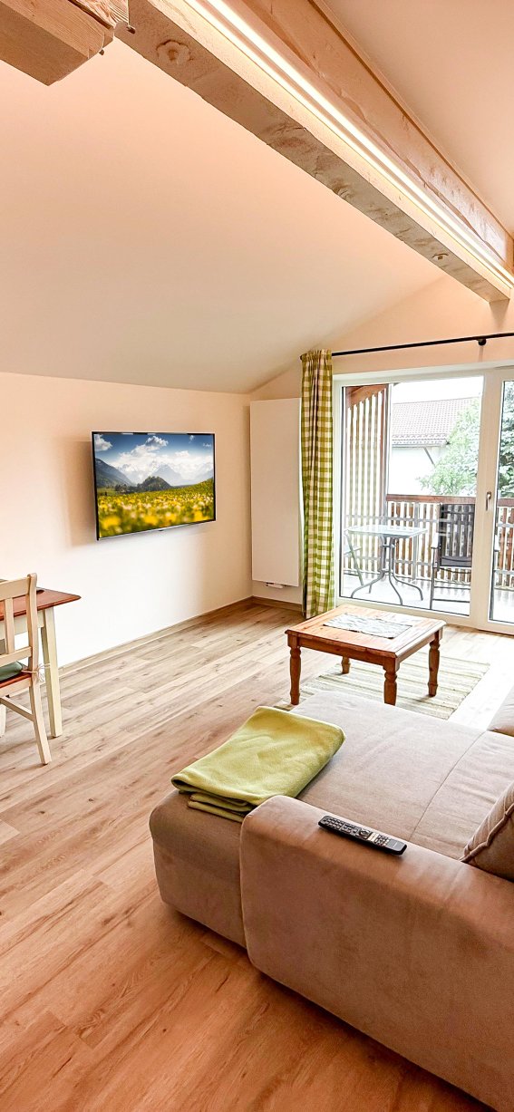 Wohnzimmer mit Essbereich und Balkon Das Bild zeigt ein Wohnzimmer mit einem Essbereich. Der Raum hat große Fenster und einen Balkon.