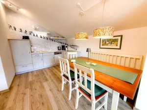 Küche und Essbereich in einer Wohnung Die Küche hat einen Esstisch mit Stühlen und eine schöne Wandgestaltung. Es ist hell und freundlich.