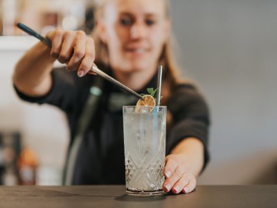 Eine Mitarbeiterin vom PANORAMA Allgäu-Spa-Resort in Rückholz finalisiert einen Cocktail