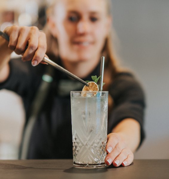 Eine Mitarbeiterin vom PANORAMA Allgäu-Spa-Resort in Rückholz finalisiert einen Cocktail