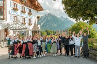 Mitarbeiter vom Hotel Prinz-Luitpold-Bad in Bad Hindelang stehen für ein gemeinsames Bild zusammen und heben die Hände