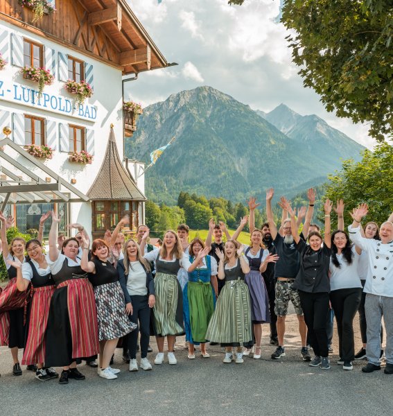 Mitarbeiter vom Hotel Prinz-Luitpold-Bad in Bad Hindelang stehen für ein gemeinsames Bild zusammen und heben die Hände