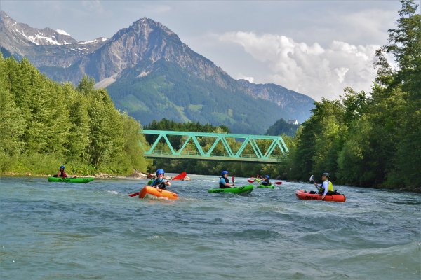 Ein Paddler steuert ein wendiges Packraft auf der Iller im Allgäu als selbstbestimmte Rafting-Alternative.