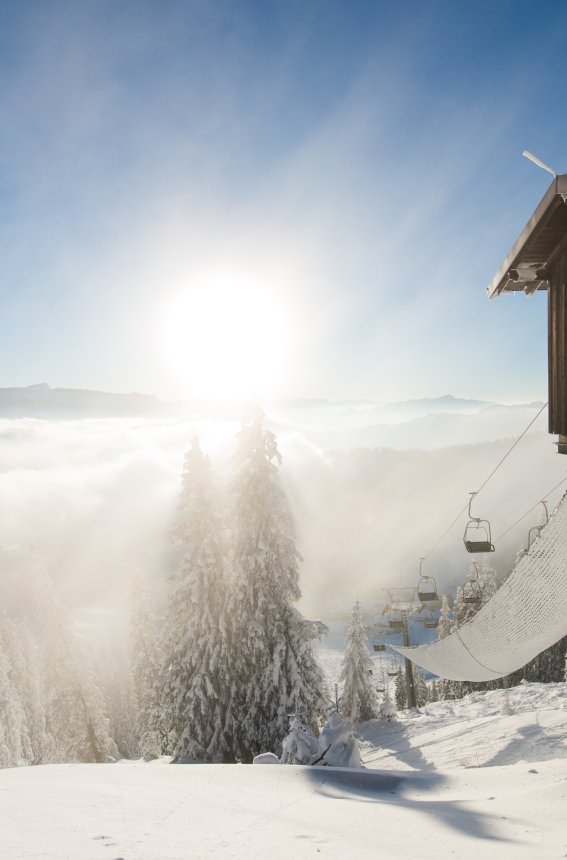 Bei klarem Wetter glänzt der Schnee unter der Morgensonne. Eine Skiliftstation steht einsam in der winterlichen Landschaft.