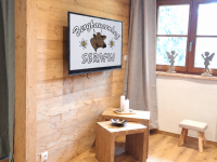 Gemütliches Chalet-Wohnzimmer mit Bergbauernhof-TV-Logo