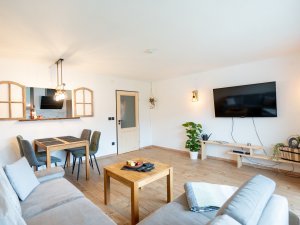 Helles Wohnzimmer mit gemütlicher Sitzecke und Esstisch, ideal für gesellige Abende oder Entspannung zu Hause.