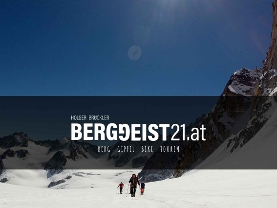 Eine Gruppe von Wanderern durchquert die verschneite Berglandschaft an einem sonnigen Tag in den Alpen.