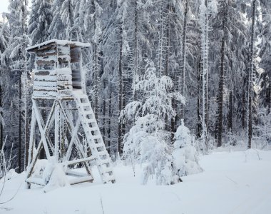 Hölzerner Jägerstand im tief verschneiten Wald – Namensgeber der Ferienwohnung Jägerstand – Bergheimat Ferienwohnungen in Obermaiselstein-Ried im Allgäu.