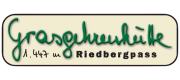 Die Riedberghütte liegt auf 1.447 Metern. Menschen besuchen die Hütte. Sie essen und trinken dort in den Bergen.