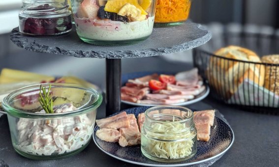 Auf einer Etagere sind verschiedene kalte Speisen und Snacks prächtig angerichtet, ideal für eine herrliches Frühsueck-