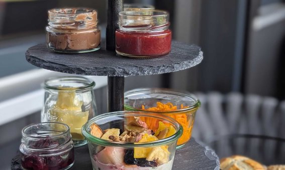 Leckers Frühstück in kleinen Gläsern auf einer Etageren-Platte, serviert in einem modernen Stück in einem Café.