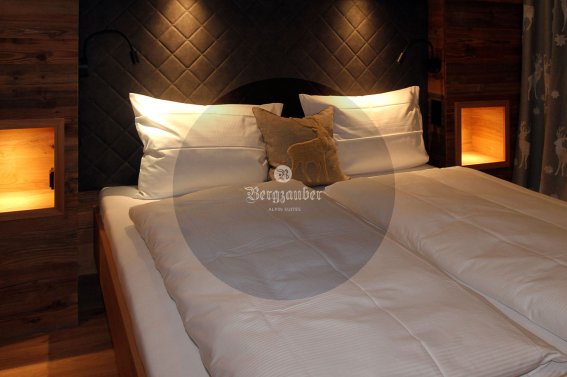 Elegantes Schlafzimmer mit zwei Betten, Holzdetails und warmem Licht für eine gemütliche Atmosphäre.