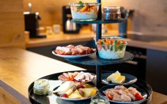 Auf einem Tisch stehen verschiedene Speisen und Getränke für das Frühstück bereit. Viele Farben und Formen sind zu sehen.