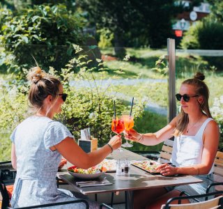 two ladies cheering with refreshing aperol spritz