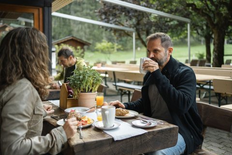 Beobachten Sie auf der Terrasse des Restaurant Oberstdorf, wie die Sonne im Tal aufgeht und sich langsam ihren Weg über die Berge kämpft.