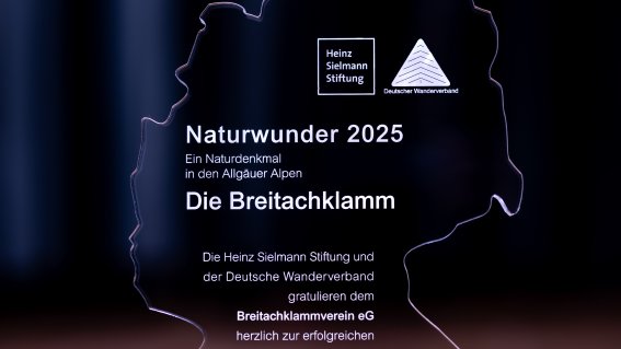 Ehrung für die Breitachklamm Eine Auszeichnung für die Breitachklamm Allgäu/Kleinwalsertal steht auf einem Tisch. Es ist ein symbolischer Moment der Anerkennung.