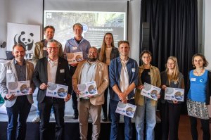 Vertreter der Breitach stehen zusammen und zeigen ihre Nominierungsurkunden der Flussfeier des WWF in Kempten