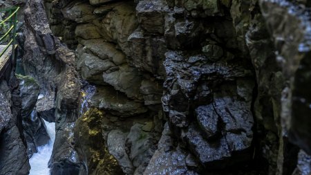 In einer engen Schlucht fließt Wasser zwischen großen Felsen. Die Wände sind steil und aus grauem Gestein.