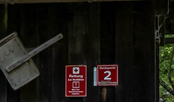 Notfallmeldung am Meldepunkt Ein Schild zeigt den Standort eines Meldesystems für Notfälle. Die Vorgehensweise wird auf den Schilder erklärt.