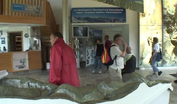 Besucher im Informationszentrum Breitachklamm Menschen bewegen sich im Informationszentrum der Breitachklamm im Jahr 2006. Eine Wand zeigt Bilder und Informationen.