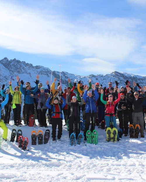 Lustige Truppe beim Schneeschuhwandern in den Alpen