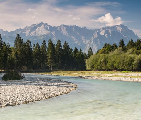 W ciepłe dni wycieczka nad górnobawarską rzekę Loisach to strzał w dziesiątkę! Stamtąd roztacza się fantastyczny widok na Zugspitze.