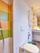 Mit neuem Farbkonzept, wandhohem Spiegel & großer Dusche überzeugt das Bad im Explorer Hotel Garmisch