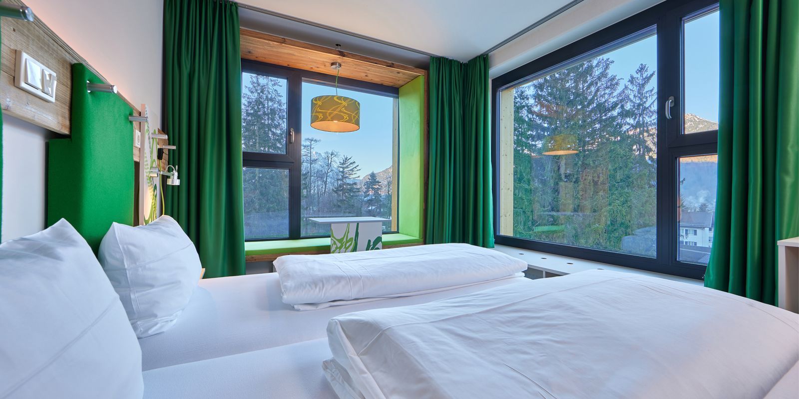 Gemütliche Betten und toller Ausblick aus den Design-Zimmern im Explorer Hotel Garmisch in Farchant in Oberbayern.