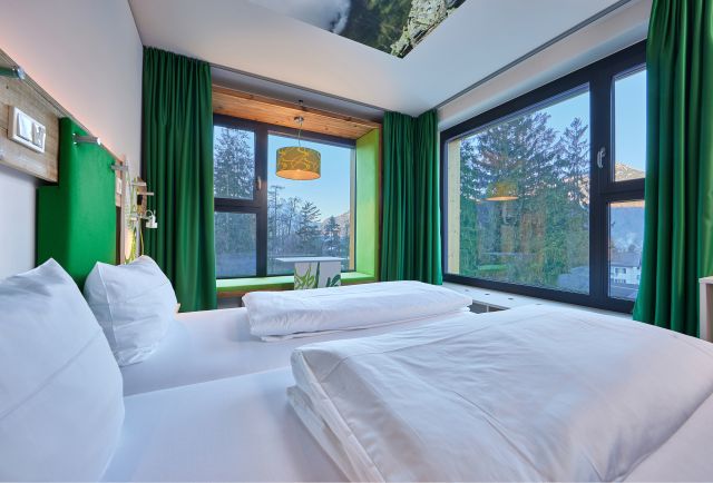Gemütliche Betten und toller Ausblick aus den Design-Zimmern im Explorer Hotel Garmisch in Farchant in Oberbayern.