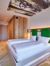 Frisches Grün und warme Holztöne erwarten Dich neben vielen Ablagemöglichkeiten im Hotelzimmer in Farchant